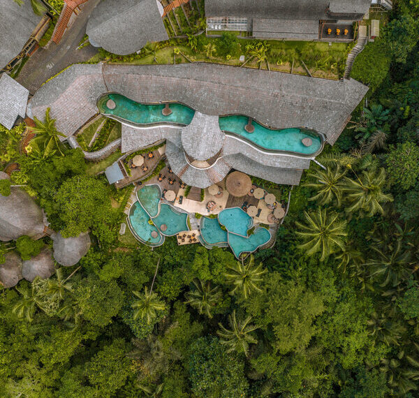 A breathtaking K Club Ubud, revealing its exquisite pool design harmoniously intertwined with lush jungle landscapes, offering guests a refined eco-luxury retreat immersed in the natural beauty of Ubud, Bali.